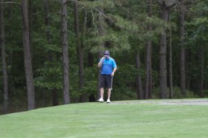 tmba golf tournament 2016 man on phone on course near woods