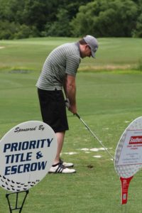 tmba golf tournament 2016 man bent over tee before shot