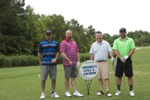 tmba golf tournament 2016 4 men posing with sign priority golf green