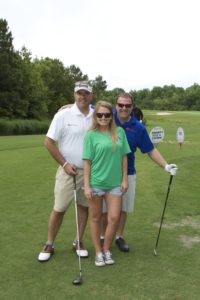 tmba golf tournament 2016 trio posing on green with putter driver